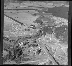 Murupara, Whakatane District, Bay of Plenty, showing State Highway 38 with workers cabins and newly constructed timber mill site foreground, and housing sudivision, with pine plantation and open valley beyond