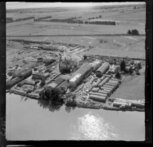 Whakatane Board Mills, Whakatane, Bay of Plenty, showing wood pulp processing plant besides the Whakatane River, timber yard on Mill Road and State Highway 30, with open land to coast beyond