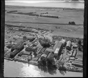 Whakatane Board Mills, Whakatane, Bay of Plenty, showing wood pulp processing plant beside the Whakatane River, Mill Road with timber yard and State Highway 30, with coast and Motuhora Island beyond