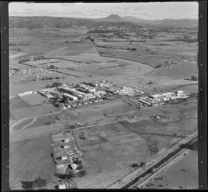 Whakatane Board Mills, Whakatane, Bay of Plenty, showing wood pulp processing plant besides the Whakatane River with and Mill Road and timber yard, Kope Canal Road and canal, with view inland to Mt Edgecumbe and farmland beyond