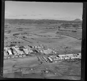 Whakatane Board Mills, Whakatane, Bay of Plenty, showing wood pulp processing plant and timber processing yard, with view inland to farmland and Mt Edgecumbe and hills beyond
