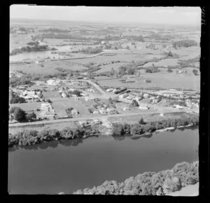 Taupiri, Waikato, showing township on the banks of the Waikato River and Great South Road (State Highway 1) and railway line, residential housing and school, with Mangawara Stream and farmland beyond