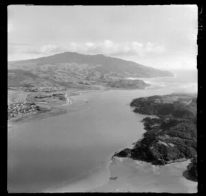 Raglan, Waikato, view along the coast to the mouth of Raglan Harbour showing part of Raglan Township and Wainui Stream, with farmland and Mt Karioi beyond