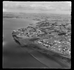 Raglan, Waikato, view along the coast of inner Raglan Harbour with Raglan Township with tidal flats, farmland beyond