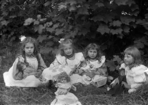 Four young girls with dolls, having a tea party
