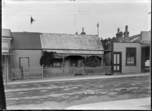 Unidentified street in Wellington, showing buildings including a wooden cottage
