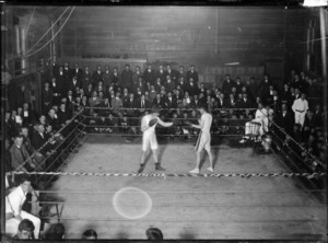Boxing match and a crowd of male onlookers
