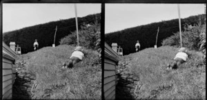 Brothers Edgar Richard and Owen William Williams playing war game in the garden of the Williams' Royal Terrace house, Kew, Dunedin, including British flag and gun