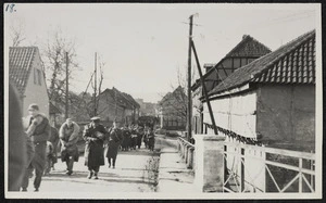 Allied prisoners passing through a deserted German village