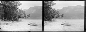 Canoes on the shore of lake [Te Anau?], Southland Region, including unidentified man
