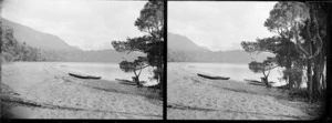 Canoes beached on shore of unidentified lake, Southland Region