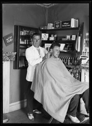 Barber Roy Bartlett giving Russell Tomlinson a haircut in the Bottom Road barbershop