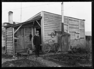 Joseph Divis standing outside his cottage
