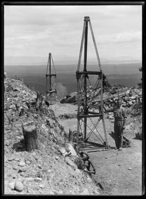 Man posed with incomplete pylons under construction for aerial ropeway