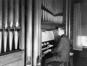 Mr Nash playing an organ in a house in Coromandel Street, Newtown, Wellington