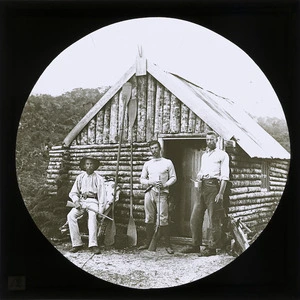 Six men outside a hut