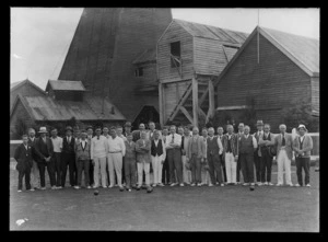 Group of bowlers posed in front of mine buildings at opening of new bowling club on 8 November 1931