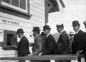 Men queuing to place bets on horses, at Trentham Racecourse