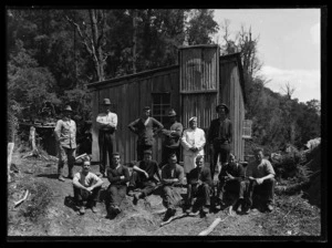 Group portrait of men including cook outside hut at the Alexander Mine