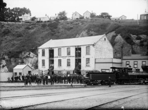 Crowd outside the Union Steam Ship Company building, Port Chalmers, and a Baldwin T Class locomotive