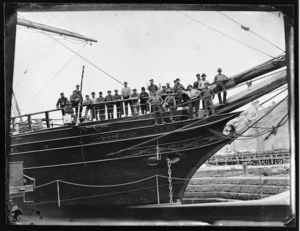 Crew of the sailing ship Timaru standing at her bow. She is in the graving dock at Port Chalmers.