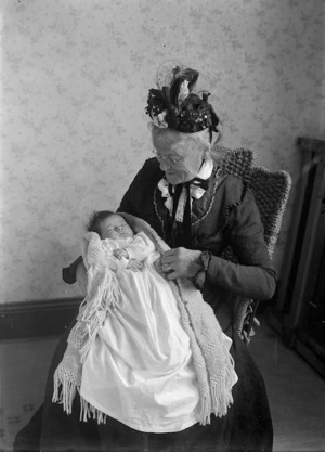 An elderly woman with a baby on her lap