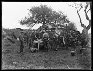 World War I soldiers preparing a meal near a damaged German tank, France