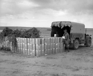 Army Service Corps stacking up tins of petrol from a truck, Western Desert, Egypt