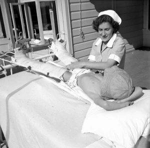 Nurse tending to a child in the Wilson Home for crippled children, Takapuna, Auckland