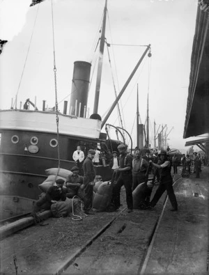 The ship, Storm, with workers carting full sacks