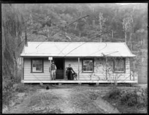 [Robert Porter, postman and storekeeper, and his wife] and dog on the porch of Tuhara Post Office, Wairoa County