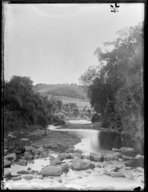 Stream with farmland and trees in the background
