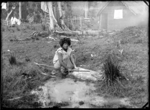 Unidentified Maori woman washing clothes on a rock, Te Kauri, Otorohanga