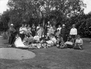 Group of people displaying Maori handicrafts, including flax kits and cloaks