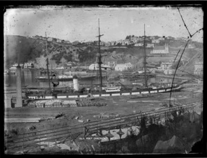 View of old Port Chalmers looking across to the steamship 'Omeo' in the graving dock; the small paddle steamer 'Golden Age' centre left; and looking up the hill with the first Anglican church, and the Methodist church in the far right.
