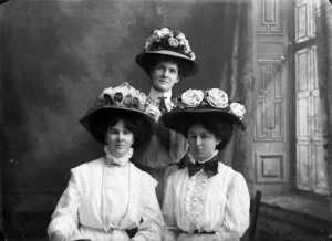 Three woman wearing floral hats