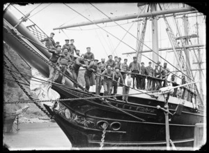 The prow of the sailing ship Otago showing her figurehead, with her crew standing in the bow.