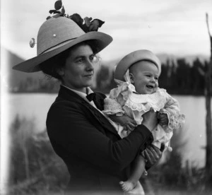 Woman wearing a hat and holding a young child
