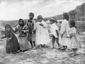 A row of seven young children performing a Maori action song