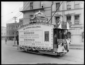 Tram decorated with World War 1 propaganda, including unidentified tram conductor and passenger, Temperance and General Life Assurance Society building in background, Cathedral Square, Christchurch