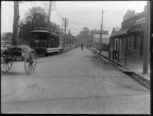 Oxford Terrace, Christchurch, showing a bicycle repair shop and locksmiths at right, and traffic including tram, wooden cart, and bicycles