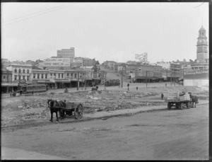 View of Queen Street, Auckland, from Wellesley Street, with vacant lot in foreground and including Auckland Town Hall, photography studio of WH Bartlett and advertising signage for Laborlite soap