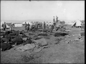 World War I troops with equipment including blankets, harnesses and saddles, with army tents pitched in background, possibly in Christchurch