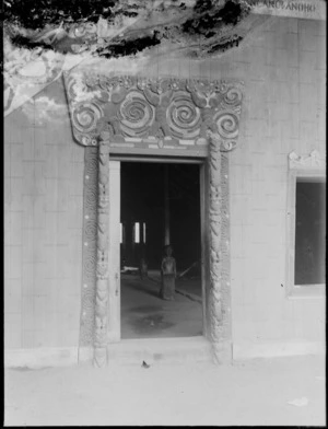 Exterior of Te Tokanganui-A-Noho Meeting House, Te Kuiti, showing carved wooden doorway window surround and figures on interior posts