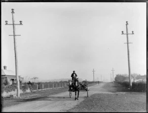 Unidentified man driving a horse-drawn cart down an unidentified rural road, [Christchurch?]