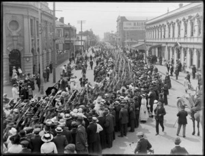 View of High Street, Christchurch, during a World War I infantry parade showing furniture showroom of Strange & Company, Loe's drapery store, and Lawrence and Kircher furnishing warehouse