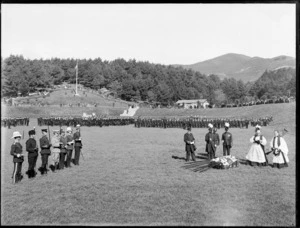 Military ceremony, showing the presentation of The Colours of the Infantry to members of the Honour Guard by Lord William Lee Plunket and officiated by members of the clergy, in a park, possibly Christchurch