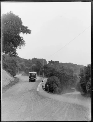 A winding dirt road in the hills above Dunedin, showing a bus on its way to The New Zealand and South Seas International Exhibition at Logan Park