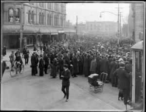World War I soldiers marching down street beyond Cathedral Square, Christchurch City, with crowd looking on, Reuters Telegram Company building in background