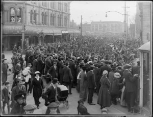World War I soldiers marching down street beyond Cathedral Square, Christchurch City, with crowd looking on, Reuters Telegram Company building in background